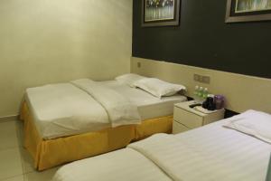 Postel nebo postele na pokoji v ubytování Putra One Avenue Hotel