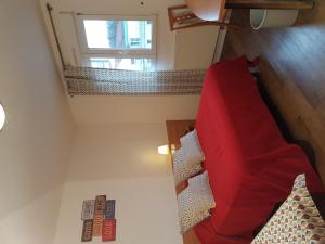 a bedroom with a red bed and a window at Hôtel Des Bois in Seltz