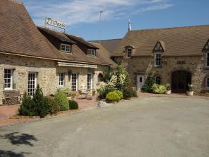 un grand bâtiment avec un parking en face de celui-ci dans l'établissement Logis Hotel Oasis, à Villaines-la-Juhel