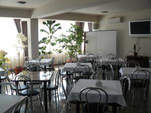 a dining room with tables and chairs and a whiteboard at Euro House Hotel in Baia Mare