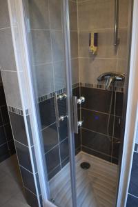 une douche avec une porte en verre à côté d'un lavabo dans l'établissement Logis-Hôtel LE CARNOT, à Bolbec