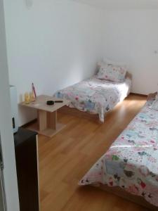 a room with two beds and a table in it at Magnolia Guest house in Haskovo