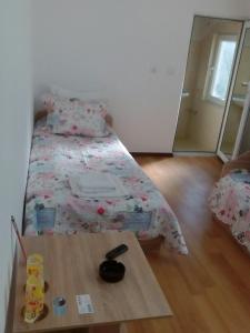 a small bedroom with a bed and a wooden table at Magnolia Guest house in Haskovo