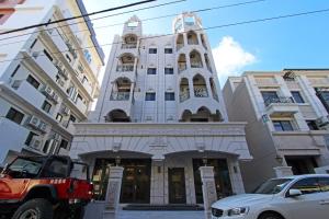 a white building with a tower on a street at Fardo Homestay in Hualien City