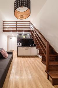a living room with a staircase and a couch at 2 Nights Apartments - great location, right next to Main Rail and Bus Station, 10 min to Main Square by foot in Krakow