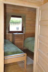 two beds in a cabin with a window at Northwick Farm Lodges in Broadway