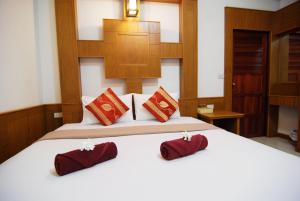 a bedroom with a bed with red pillows on it at Nature Beach Resort, Koh Lanta in Ko Lanta