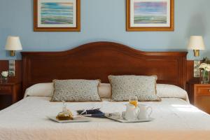 a bed with two plates of food on it at Hotel Restaurante Emilio in Hellín