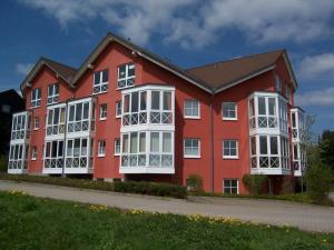 ein rotes Gebäude mit weißen Fenstern auf einer Straße in der Unterkunft Appartement Schultz - Grüne Aue in Braunlage