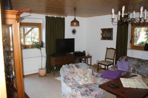 a living room with a couch and a tv at Ferienwohnung Weilerbach in Weilerbach