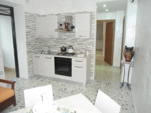 a kitchen with white cabinets and a stove top oven at H.ave in Pompei