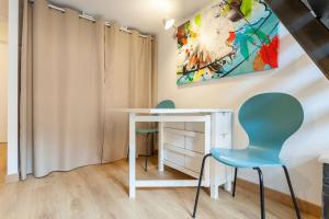 Habitación con escritorio blanco y 2 sillas. en Appart Touriste, en Lyon