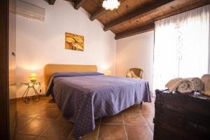 a bedroom with a bed with a blue blanket and a window at Appartamento Le Terrazze in Castellammare del Golfo