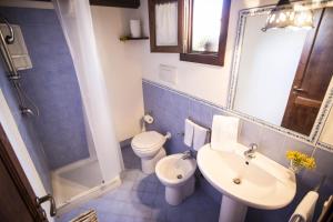 a blue tiled bathroom with a toilet and a sink at Appartamento Le Terrazze in Castellammare del Golfo