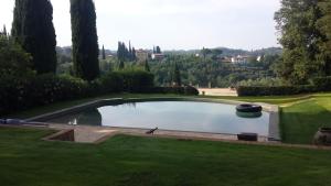 una piscina en un jardín con una colina al fondo en I Magazzini en Marti