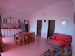 a living room with a table and a red couch at Apartman Luburić in Pinezici