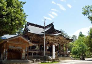 a wooden building with a flag in front of it at Hotel New Otani Nagaoka in Nagaoka