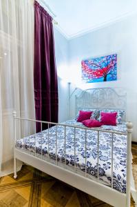 una camera da letto con un letto bianco e cuscini rosa di Stylish Studio near Rynok square a Lviv
