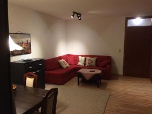 a living room with a red couch and a table at Grubhof in Sankt Martin bei Lofer