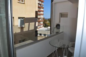a balcony with a glass table and a window at P L PANAGIOTIS Apartment in Larnaka