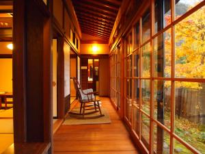 a porch with a rocking chair in a house at Yamazatonoiori Soene in Takayama
