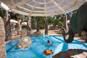 an elephant is playing in a swimming pool with an elephants trunk at Agamim by Isrotel Collection in Eilat