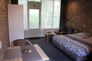 a hotel room with a bed and a table and chairs at Motel Paradiso in Bad-Nieuweschans