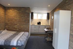 um quarto com uma cama e uma parede de tijolos em Motel Paradiso em Bad-Nieuweschans
