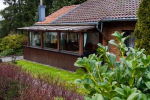 ein Haus mit Wintergarten mit Dach in der Unterkunft Ferienhaus "Kleiner Onkel" in Honerath