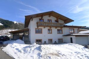 a building with a balcony on top of a pile of snow at Ferienwohnung Zirmheim in Westendorf