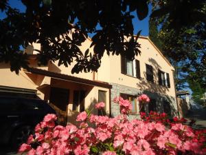 uma casa com flores cor-de-rosa em frente em La Sora Bice em Ponte Felcino