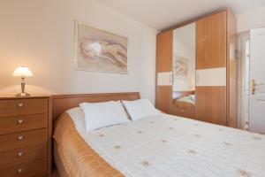 een slaapkamer met een bed, een ladekast en een spiegel bij Apartments Kalalarga Deluxe- city centre&balcony in Makarska