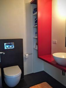 a bathroom with a white toilet and a sink at Appartement Novotna in Ponte Tresa