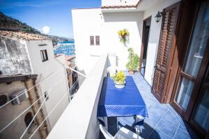 a balcony with a blue table with a view of the ocean at Appartamento La Marina in Castellammare del Golfo