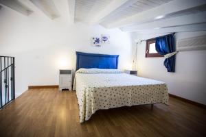 a bedroom with a bed in a room with blue curtains at Appartamento La Marina in Castellammare del Golfo