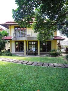 a yellow house with a balcony and a yard at 3 Bedroom Villa TG40 on Beach Resort SDV286-By Samui Dream Villas in Bophut 