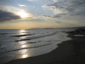 a sunset view of a beach with the ocean at Hotel Piccadilly in Lido di Camaiore