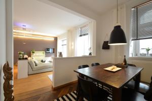 ein Esszimmer und ein Wohnzimmer mit einem Tisch und einem Sofa in der Unterkunft Asante-Design-Apartment Deluxe - very central in München