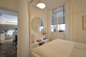 ミュンヘンにあるAsante-Design-Apartment Deluxe - very centralのベッドルーム(白いベッド1台、鏡付)