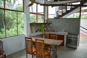 a kitchen with a wooden table and some windows at Villa Lanka Relax in Hikkaduwa