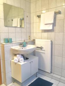 ein Badezimmer mit einem Waschbecken, einem Spiegel und Handtüchern in der Unterkunft Seestraße in Uhldingen-Mühlhofen