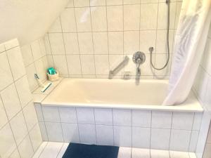 El baño incluye bañera con cabezal de ducha. en Seestraße, en Uhldingen-Mühlhofen