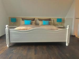 Una gran cama blanca en una habitación con lámparas azules. en Seestraße, en Uhldingen-Mühlhofen