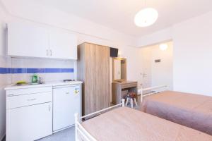 a small room with a bed and a kitchen at George Studios in Naxos Chora