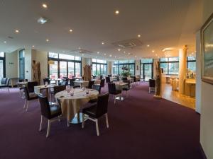 a dining room with tables and chairs and windows at Hotel du Casino in Saint-Valery-en-Caux