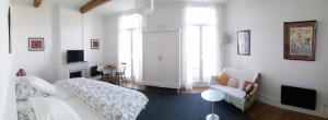 Sala de estar blanca con sofá y silla en Aumes Sweet Home Chambre d'Hôtes, en Aumes