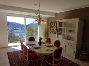 een eetkamer met een tafel en stoelen en een raam bij Sonniges Paradies in Lugano