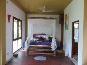 a bedroom with a bed with a canopy at Villa Lanka Relax in Hikkaduwa