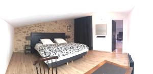 1 dormitorio con 1 cama con edredón blanco y negro en Aumes Sweet Home Chambre d'Hôtes, en Aumes