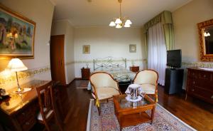 sala de estar con cama, mesa y sillas en Locanda al Castello Wellness Resort en Cividale del Friuli